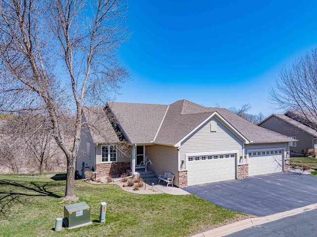 view of front of home featuring a shingled roof, an attached garage, stone siding, a front yard, and driveway