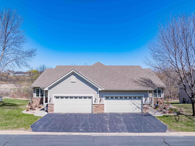 view of front facade featuring a garage, a front yard, driveway, and stone siding