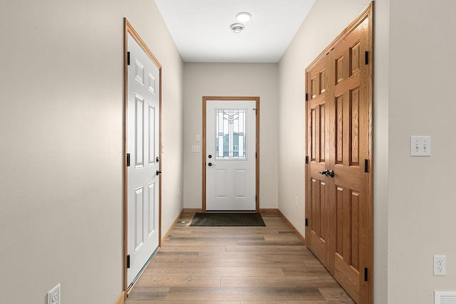 entryway with baseboards and light wood-type flooring