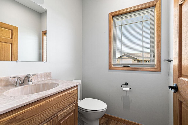 bathroom with vanity, toilet, and wood finished floors