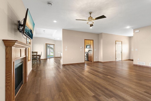 unfurnished living room with a ceiling fan, baseboards, visible vents, and wood finished floors