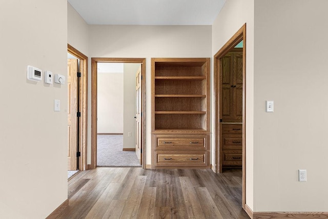 hall featuring baseboards and wood finished floors