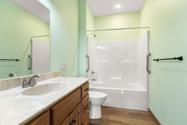 full bathroom with toilet, washtub / shower combination, wood finished floors, and vanity