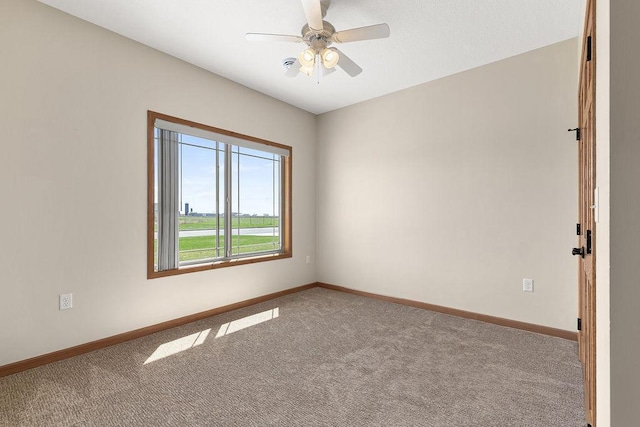 unfurnished room featuring baseboards, a ceiling fan, and carpet