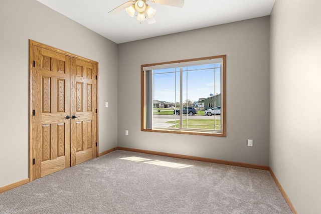 unfurnished bedroom with carpet floors, baseboards, and ceiling fan