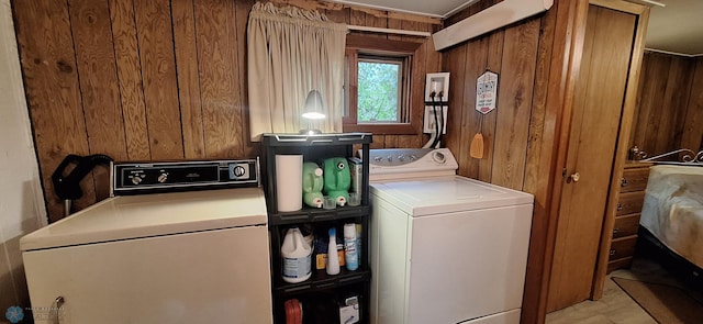 clothes washing area featuring washer / clothes dryer and wood walls