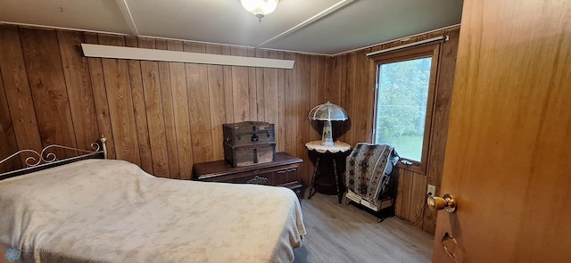 bedroom featuring wooden walls and light wood finished floors