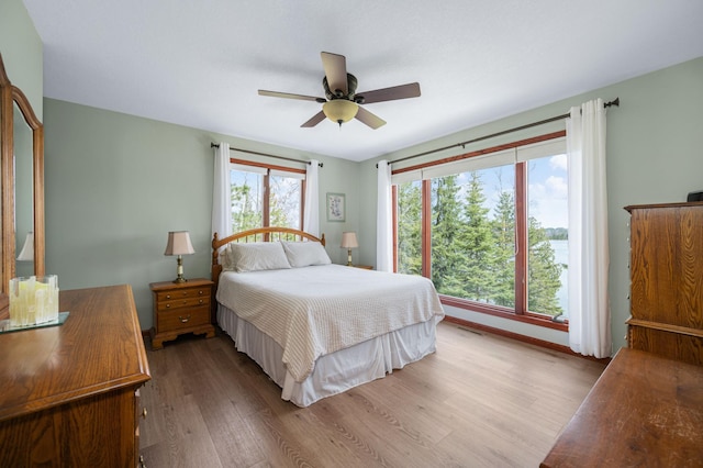 bedroom with a ceiling fan, visible vents, and wood finished floors