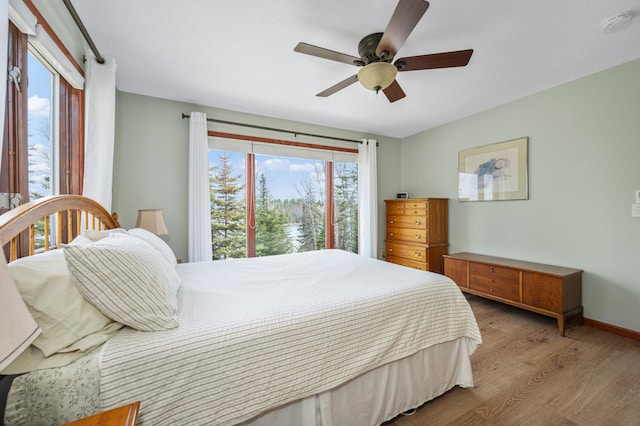 bedroom with baseboards, ceiling fan, and wood finished floors