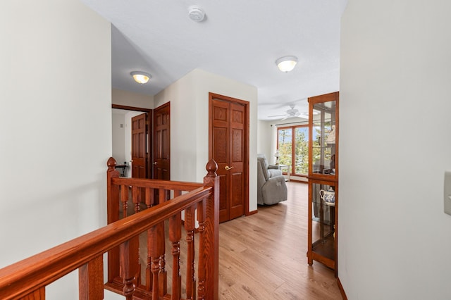 corridor featuring light wood-style floors and an upstairs landing