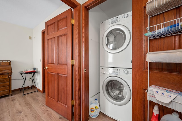 washroom featuring light wood-style floors, laundry area, and stacked washer / dryer