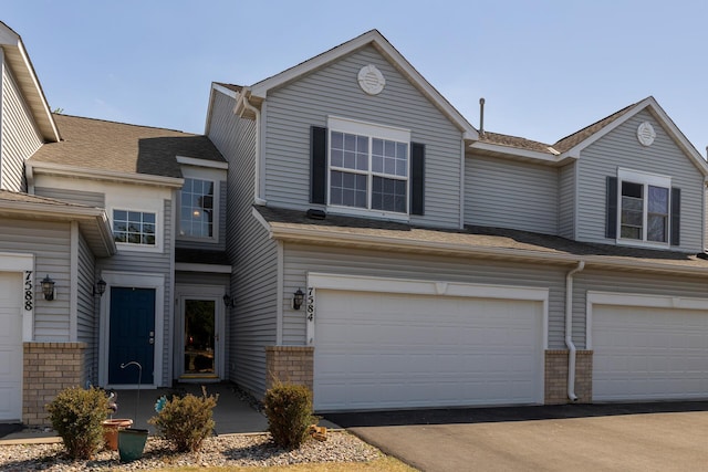 view of front of home with a garage and brick siding