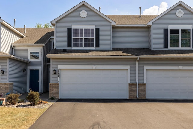 view of front of home featuring a garage, asphalt driveway, and a shingled roof