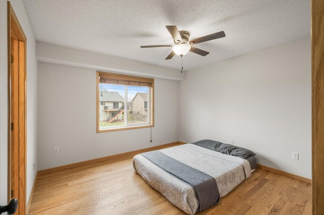 664 Highland Trl, Lino Lakes, MN 55014 - bedroom with light wood-style floors, a textured ceiling, and a ceiling fan