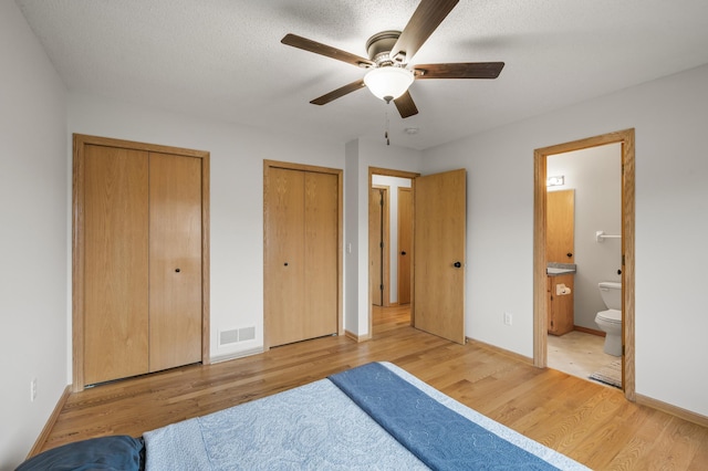 664 Highland Trl, Lino Lakes, MN 55014 - bedroom with two closets, light wood-style floors, ensuite bath, and a ceiling fan