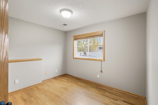 664 Highland Trl, Lino Lakes, MN 55014 - spare room with light wood finished floors and a textured ceiling