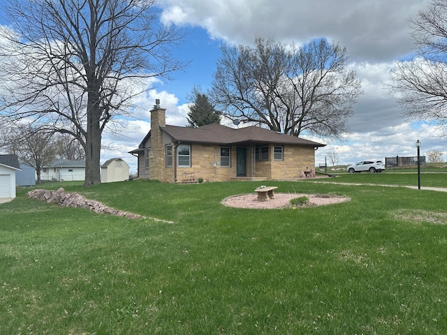 view of front of home with stone siding, a chimney, an outbuilding, a storage shed, and a front lawn