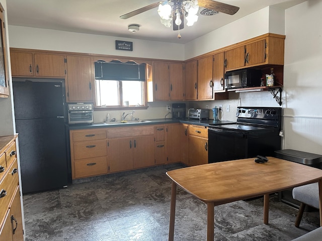 kitchen featuring brown cabinets, black appliances, dark countertops, a sink, and a ceiling fan