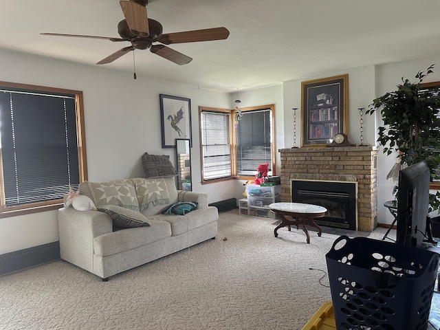 carpeted living room featuring a ceiling fan, baseboards, and a brick fireplace