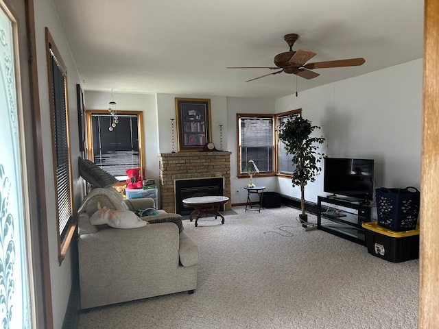 carpeted living room with a brick fireplace and ceiling fan