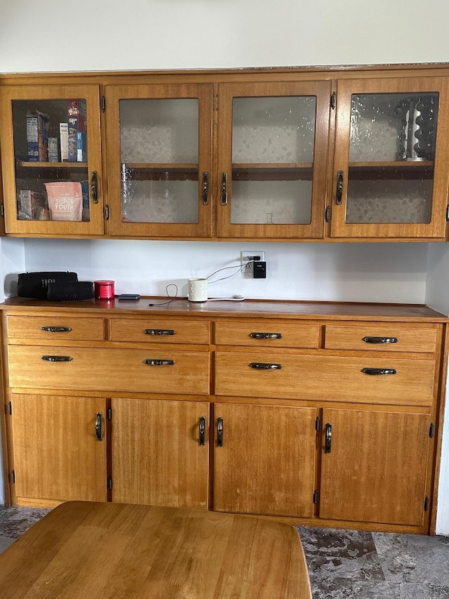 kitchen with brown cabinetry and glass insert cabinets