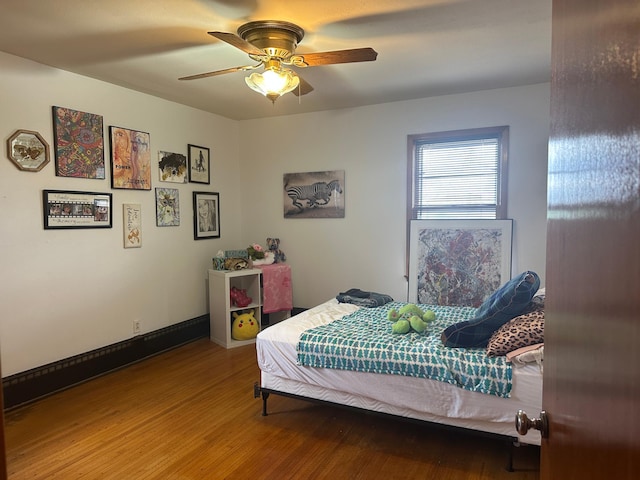 bedroom with wood finished floors, ceiling fan, and baseboards