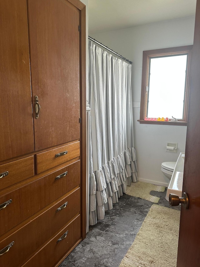 full bath with toilet and a shower with shower curtain
