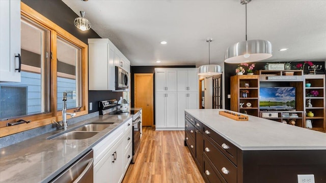 7355 Little Mary Cir SW, Alexandria, MN 56308 - kitchen featuring stainless steel appliances, a sink, white cabinets, light wood-type flooring, and pendant lighting