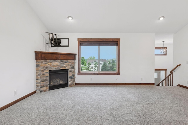 116 Wheat Field Ln, New Richmond, WI 54017 - unfurnished living room featuring carpet floors, a stone fireplace, recessed lighting, a chandelier, and lofted ceiling
