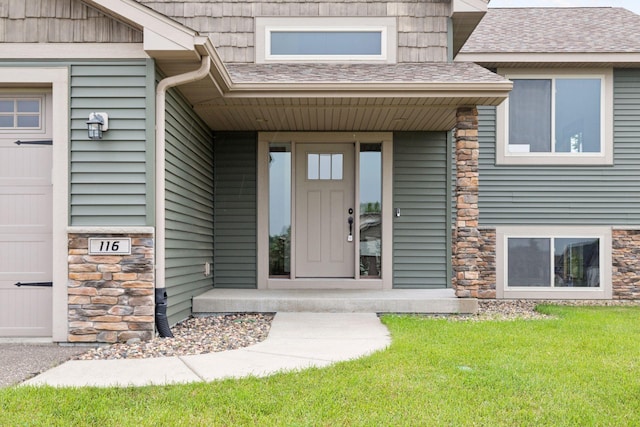 116 Wheat Field Ln, New Richmond, WI 54017 - view of exterior entry with stone siding, a yard, covered porch, and a shingled roof