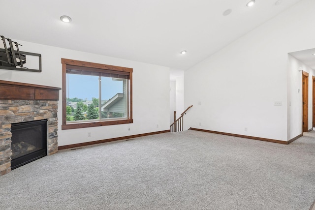 116 Wheat Field Ln, New Richmond, WI 54017 - unfurnished living room featuring carpet flooring, lofted ceiling, a stone fireplace, and recessed lighting