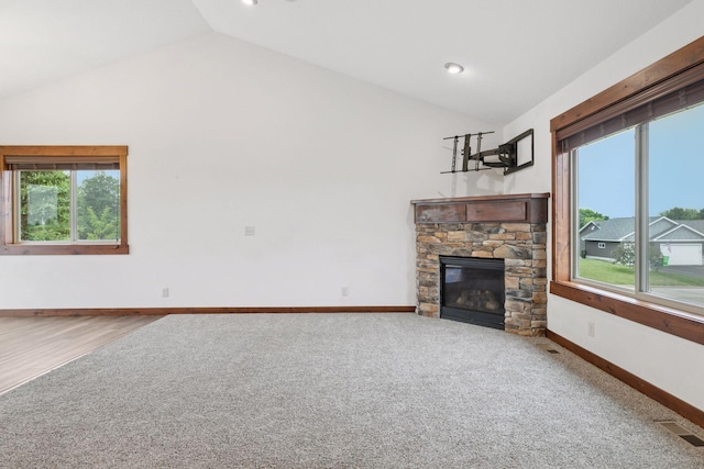 116 Wheat Field Ln, New Richmond, WI 54017 - unfurnished living room featuring vaulted ceiling, plenty of natural light, a stone fireplace, and carpet floors