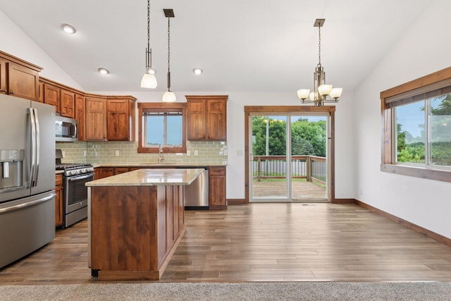 116 Wheat Field Ln, New Richmond, WI 54017 - kitchen featuring appliances with stainless steel finishes, lofted ceiling, decorative backsplash, a chandelier, and a kitchen island