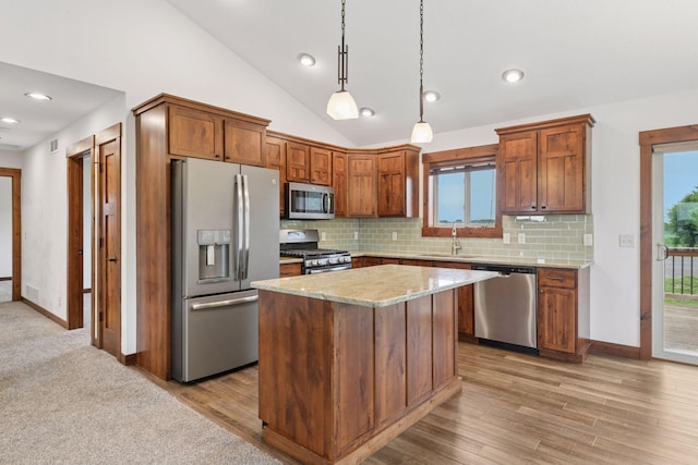 116 Wheat Field Ln, New Richmond, WI 54017 - kitchen with appliances with stainless steel finishes, lofted ceiling, decorative backsplash, a center island, and decorative light fixtures