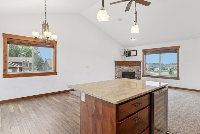 116 Wheat Field Ln, New Richmond, WI 54017 - kitchen with beverage cooler, a stone fireplace, plenty of natural light, ceiling fan, and high vaulted ceiling