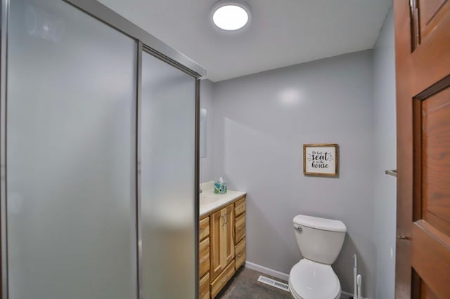 bathroom with toilet, vanity, and baseboards