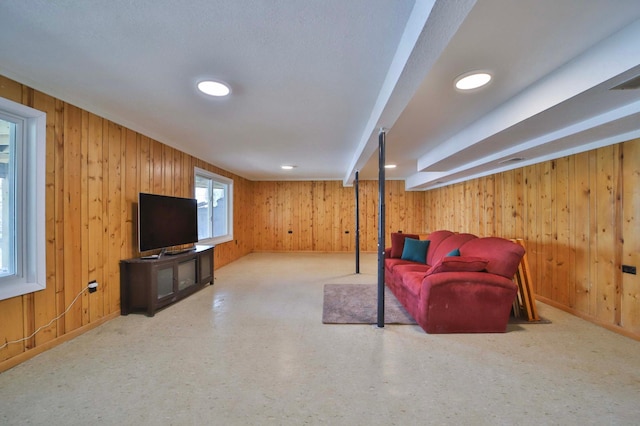 sitting room with wooden walls, carpet floors, and baseboards