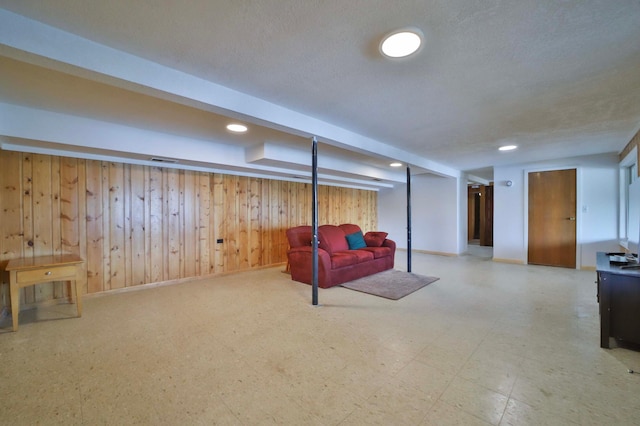 finished basement with wooden walls, recessed lighting, and baseboards