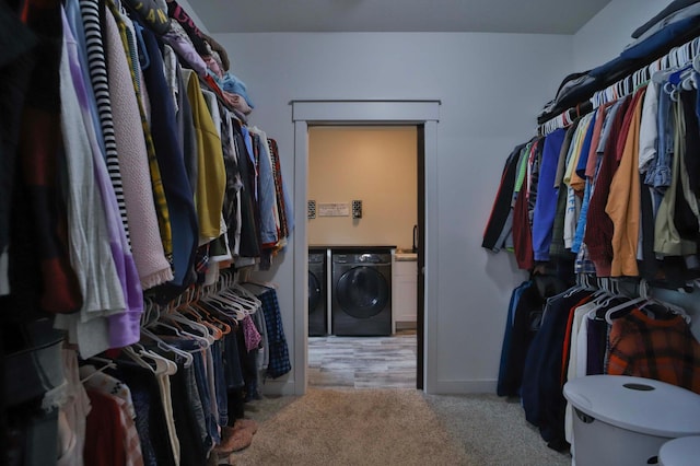 walk in closet with carpet and independent washer and dryer