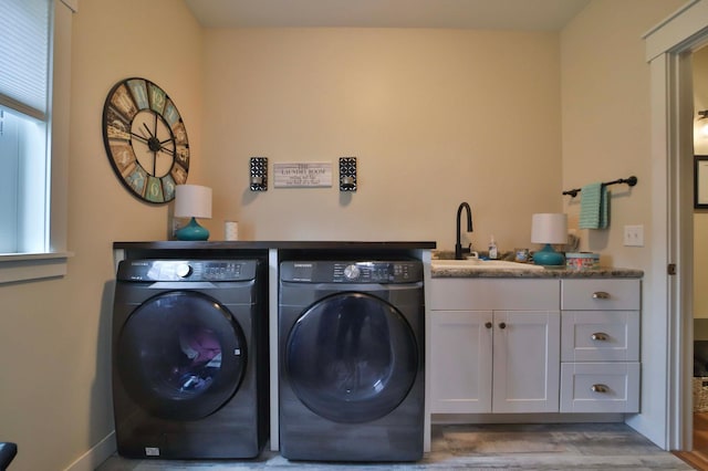 laundry room featuring a sink, cabinet space, independent washer and dryer, and wood finished floors
