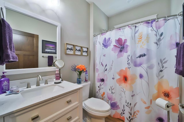 bathroom featuring toilet, curtained shower, and vanity