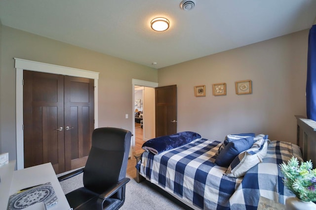 bedroom featuring visible vents, light carpet, and a closet