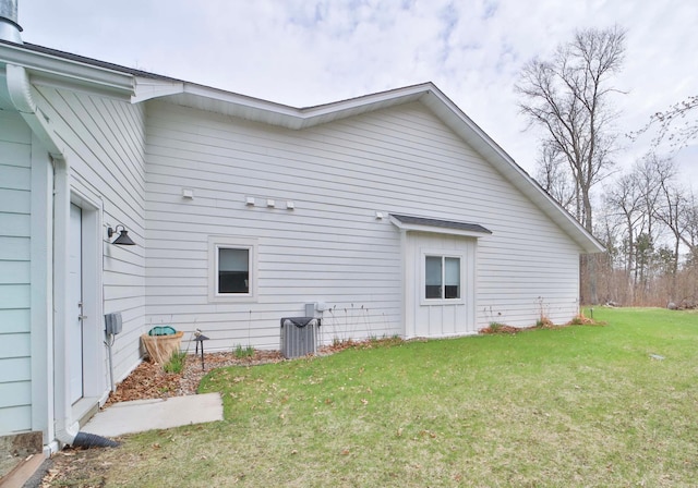 rear view of property with a yard and central air condition unit