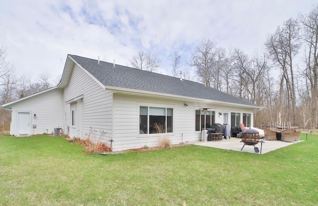 rear view of property with roof with shingles, a patio, and a yard