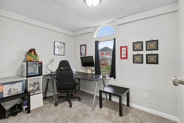 office area with a textured ceiling, baseboards, and carpet