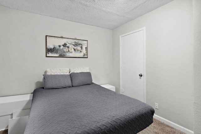 bedroom featuring carpet floors, a textured ceiling, and baseboards
