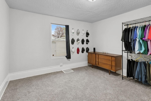 bedroom featuring baseboards, light colored carpet, a textured ceiling, and visible vents