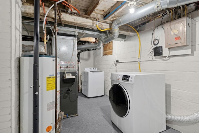 clothes washing area with separate washer and dryer, laundry area, electric panel, and gas water heater
