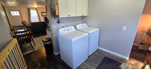 clothes washing area featuring baseboards, cabinet space, dark wood finished floors, and washing machine and clothes dryer