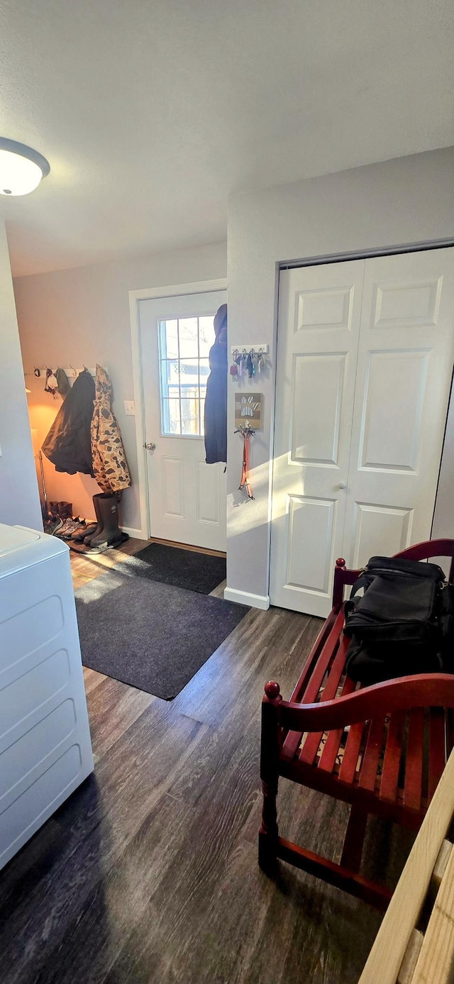 interior space featuring baseboards, washer / dryer, and wood finished floors